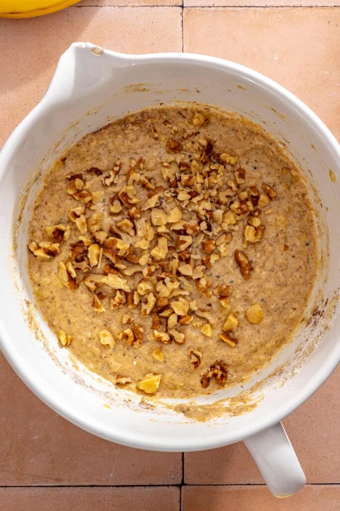 Adding walnuts to homemade banana muffin batter