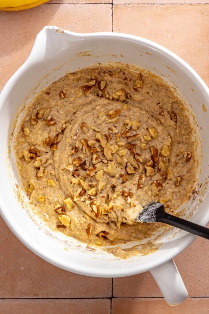 Chopped walnuts folded into toddler banana muffin batter