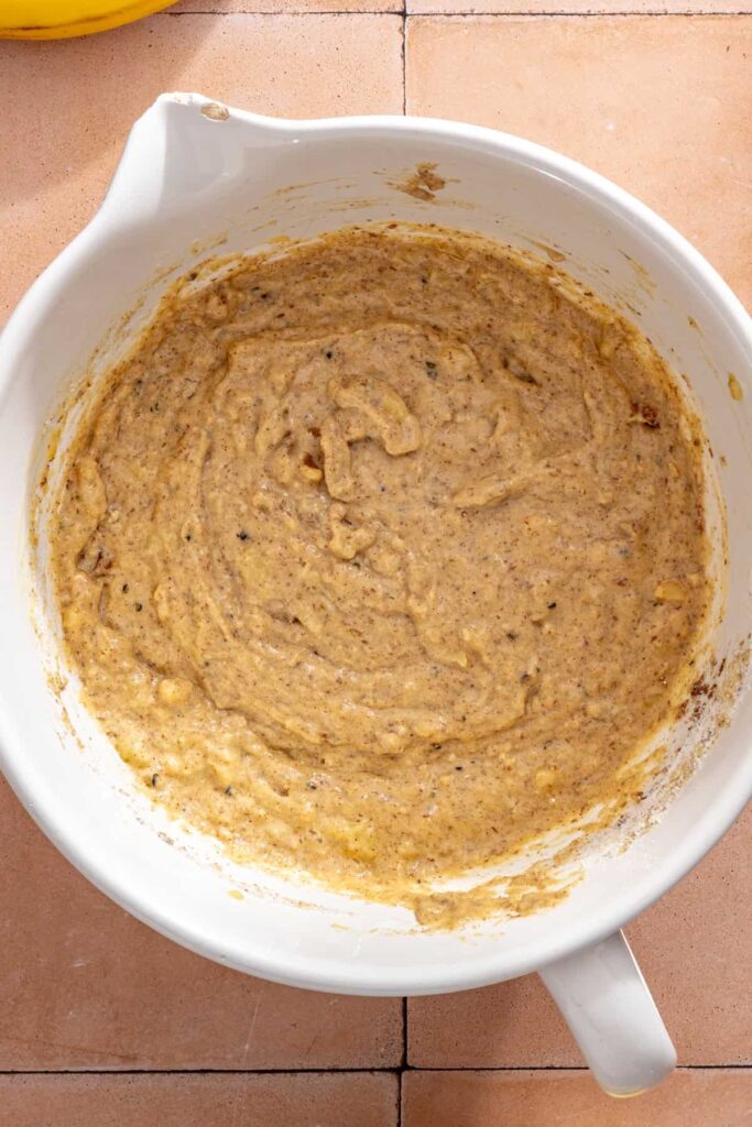 Banana muffin batter mixed with chopped walnuts before baking