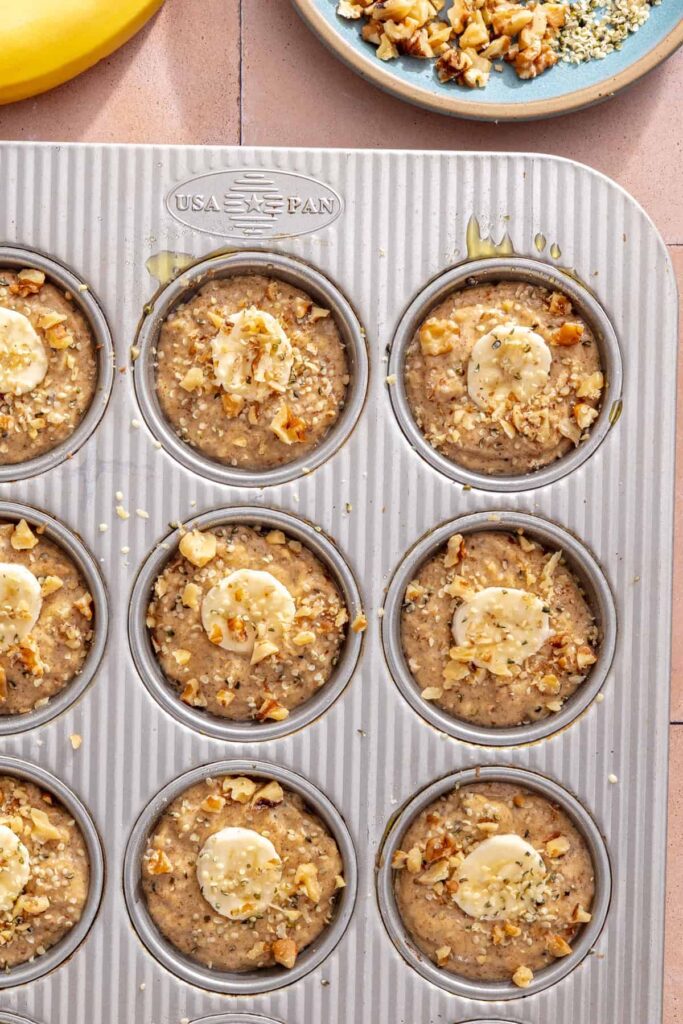 Hemp seeds and chopped walnuts sprinkled over banana muffins before baking