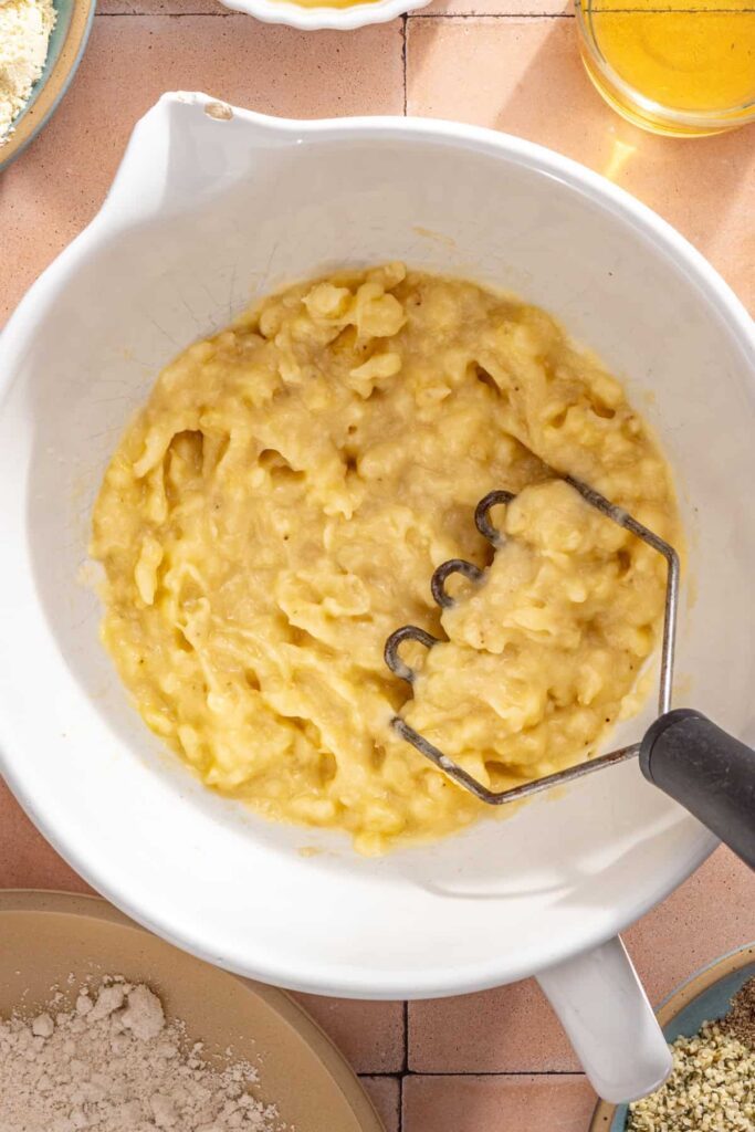 Very ripe bananas mashed in a mixing bowl for toddler banana muffins