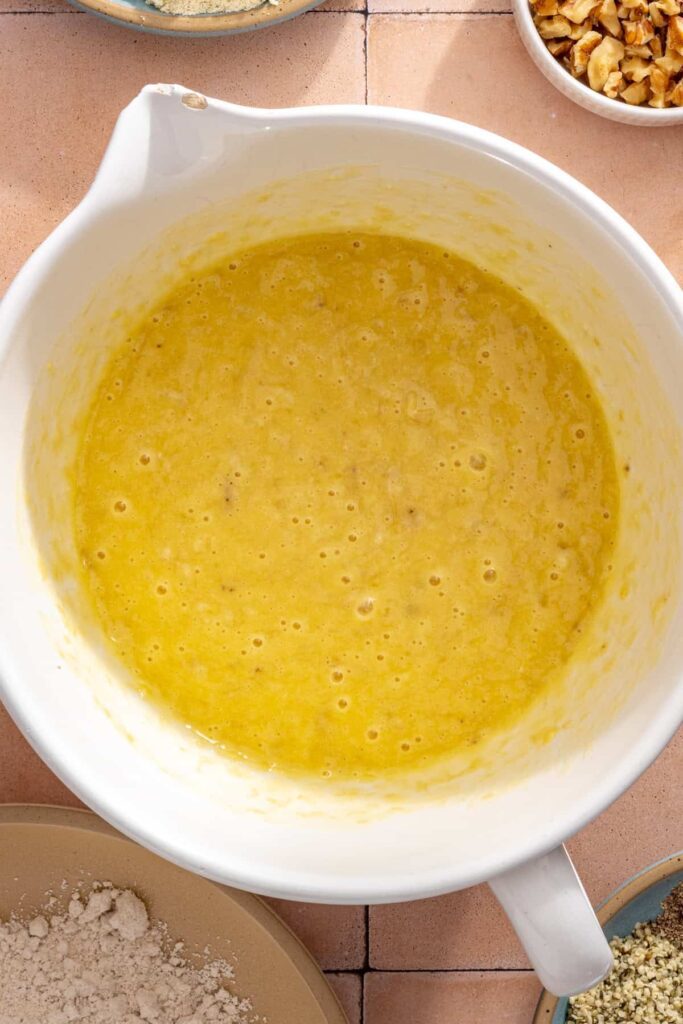 Banana muffin batter with mashed bananas, eggs, avocado oil, and vanilla
