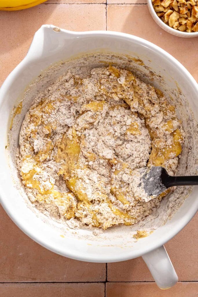 Mixing dry ingredients into homemade toddler banana muffin batter
