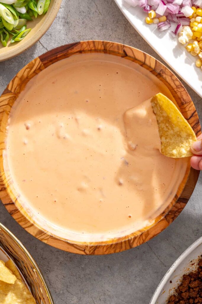 tortilla chip being dipped into high-protein cottage cheese queso