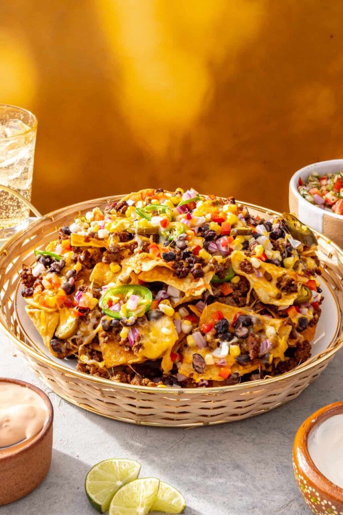 Air fryer beef nachos topped with avocado, pico de gallo, crema, and cottage cheese queso
