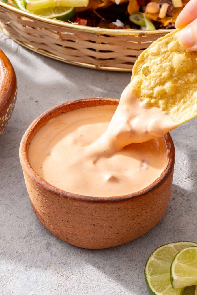 Tortilla chip dipped into creamy cottage cheese queso