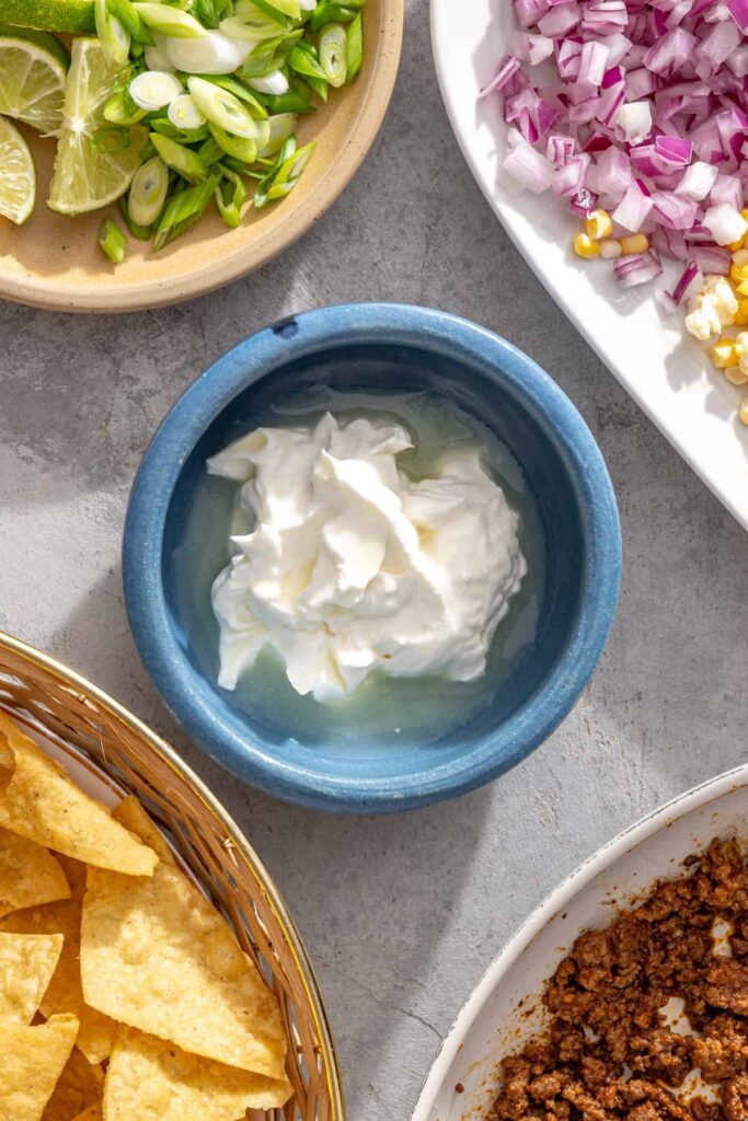 Greek yogurt, lime juice, and salt ready to be mixed into a creamy lime crema