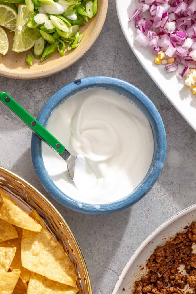 Greek yogurt lime crema whisked in a small bowl for air fryer nachos