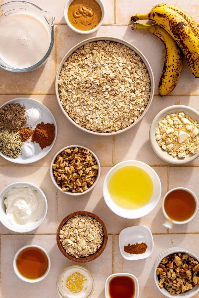 Ingredients for banana bread baked oatmeal with bananas, rolled oats, walnuts, cinnamon, maple syrup, and Greek yogurt