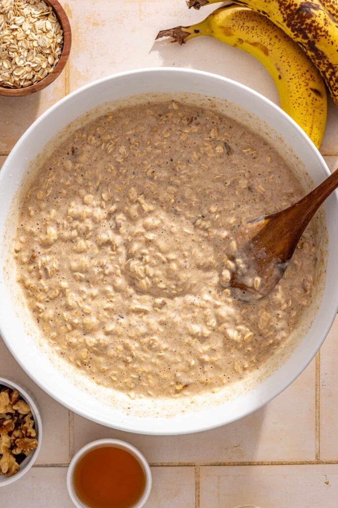 Folding chopped walnuts into the oat mixture before baking