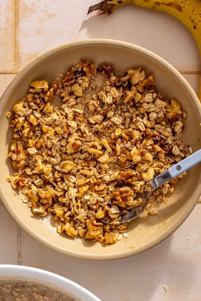 Mixing walnuts, rolled oats, maple syrup, cinnamon, and salt for the maple walnut crumble