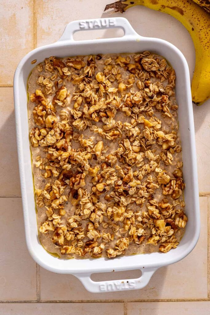 Maple walnut crumble scattered over unbaked banana bread baked oatmeal