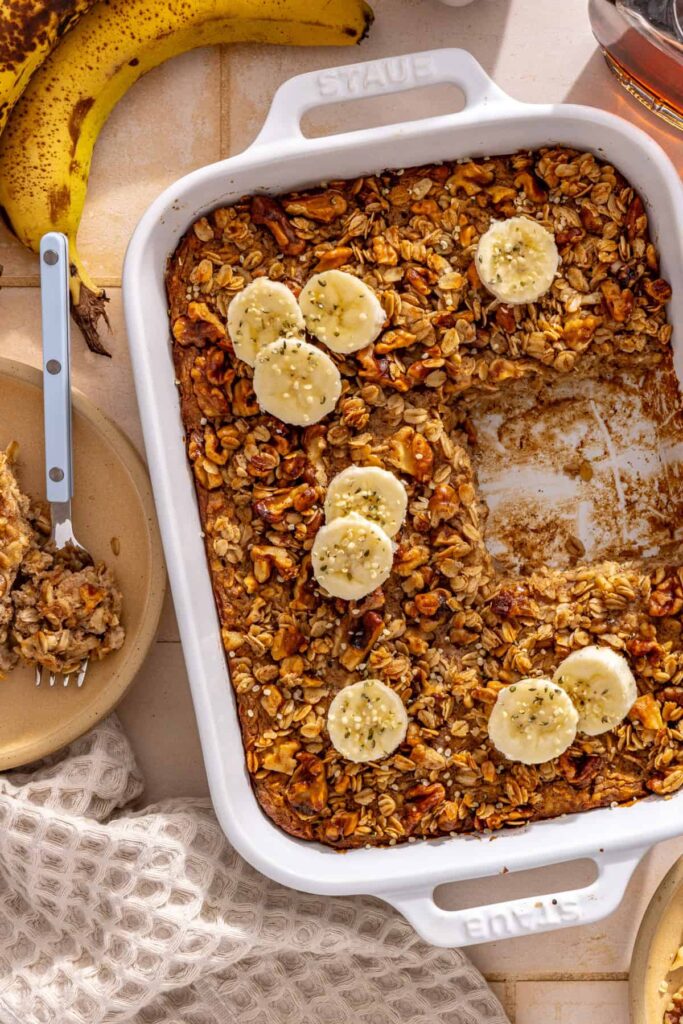 Overhead banana bread baked oatmeal topped with banana slices and maple walnut crumble