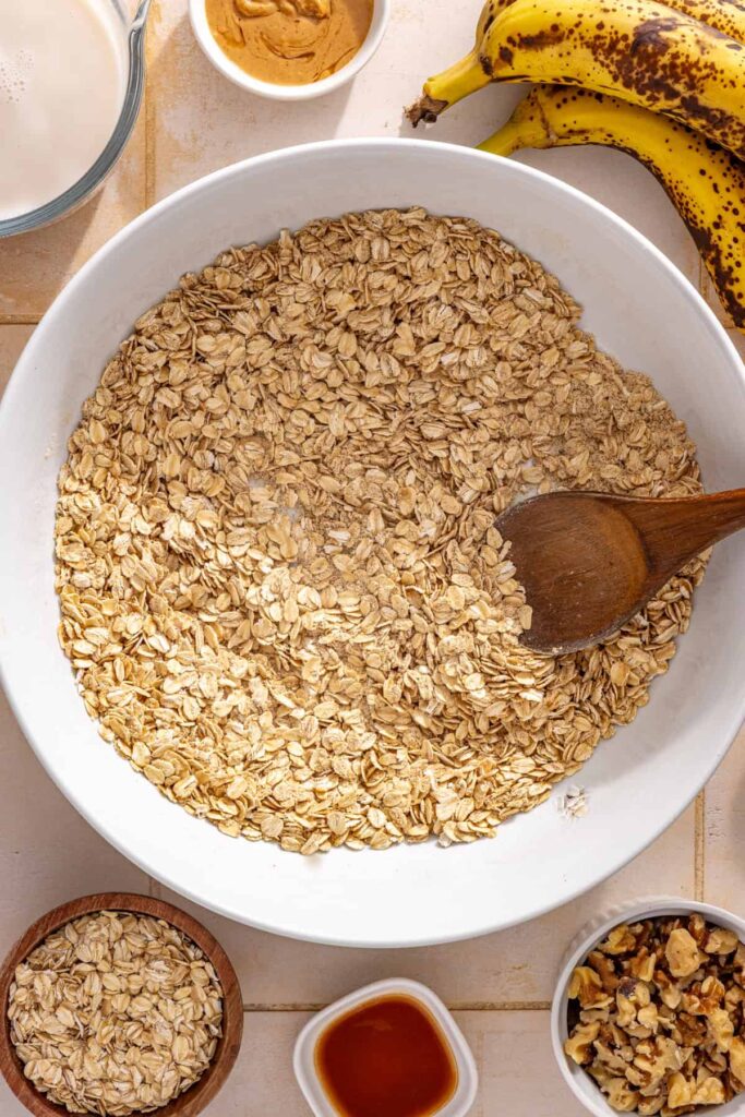 Dry ingredients for banana bread baked oatmeal being mixed in a large bowl