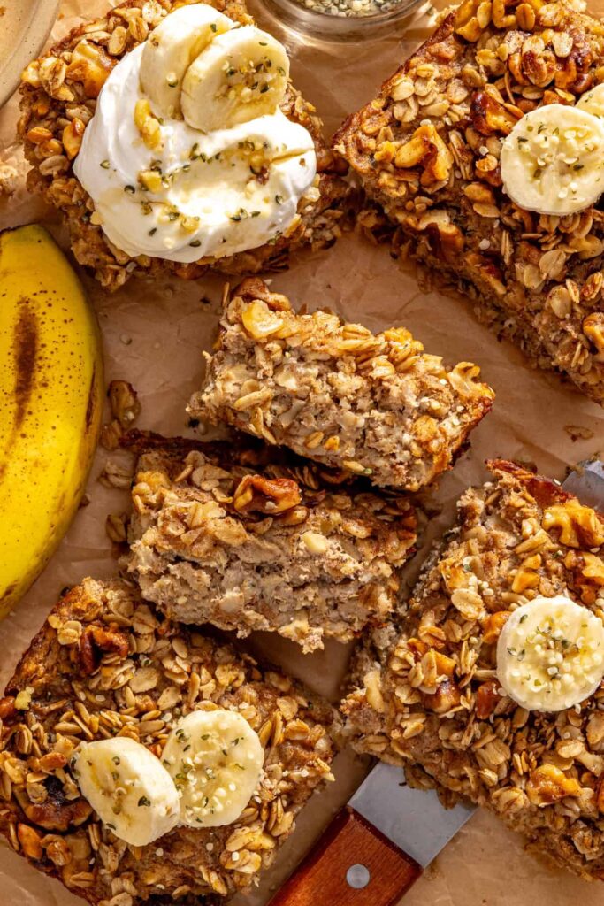 Banana bread baked oatmeal slices with maple walnut crumble and banana, showing the baked oatmeal texture