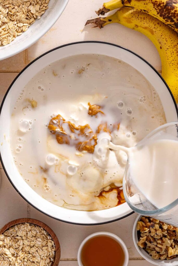 Almond milk, egg whites, maple syrup, vanilla, almond butter, and Greek yogurt added to mashed bananas