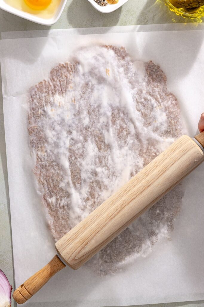 Pressing ground chicken into a thin giant chicken cutlet between parchment