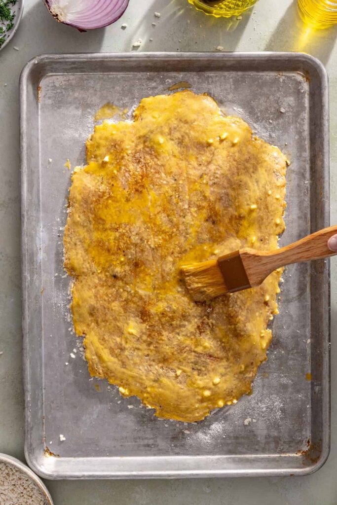 Brushing the second side of the chicken cutlet with egg wash