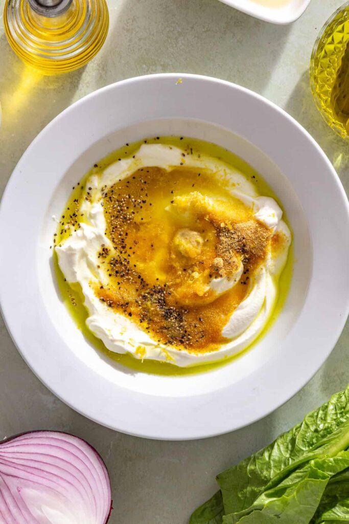 Mixing Greek yogurt with pickle juice, lemon juice, Dijon, and seasonings for pickle ranch