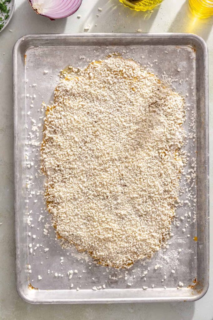 Pressing seasoned gluten-free panko onto the second side of the chicken cutlet