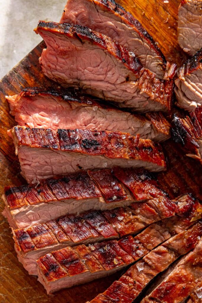 close-up of grilled flank steak sliced against the grain for serving