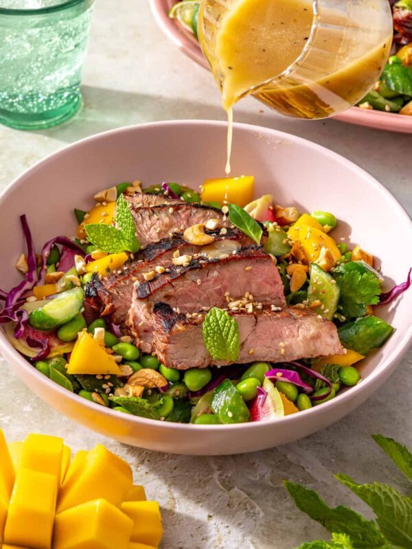 Ginger sesame flank steak with smashed cucumber mango salad drizzled with sesame lime dressing