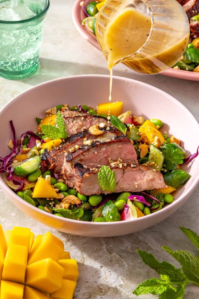 Ginger sesame flank steak with smashed cucumber mango salad drizzled with sesame lime dressing