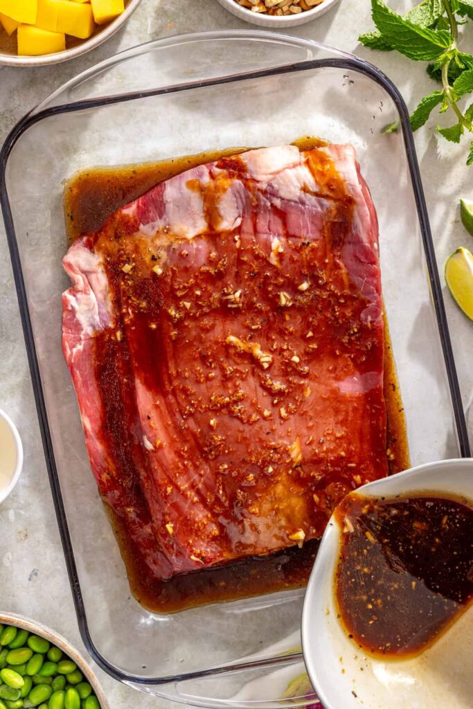 pouring the marinade into a shallow container for steak to marinate in