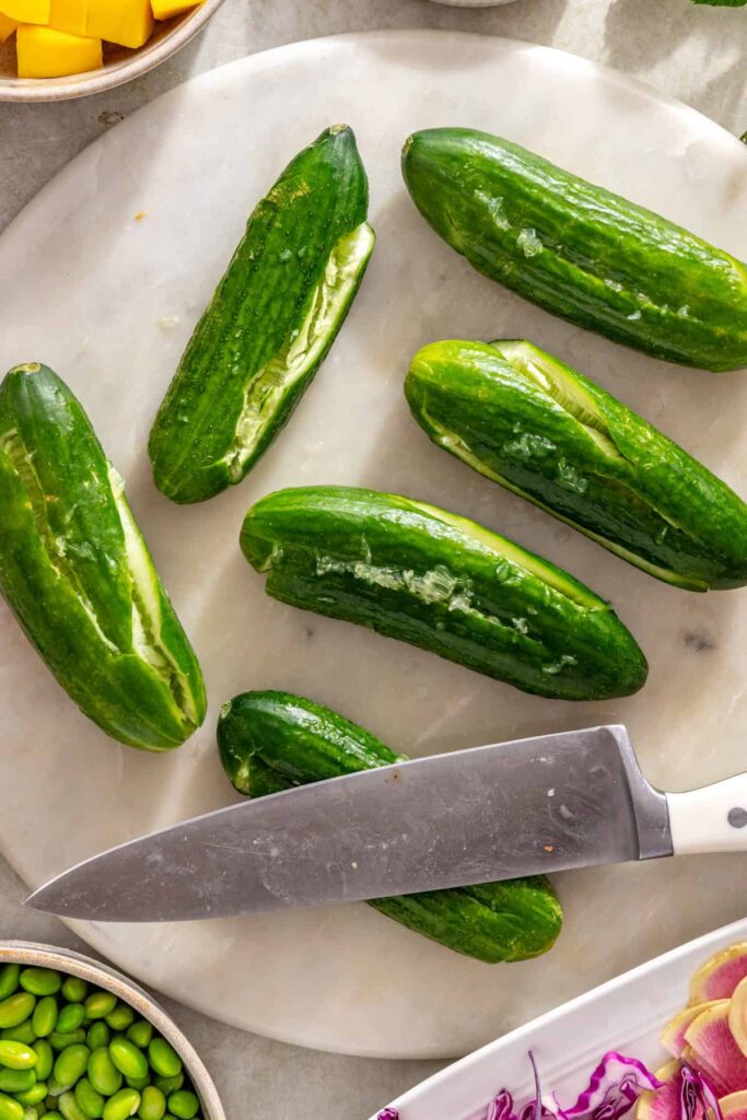 Smashing mini cucumbers for smashed cucumber mango salad