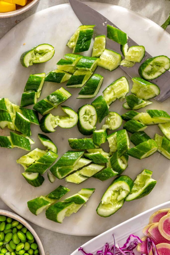 Mini cucumbers smashed with the flat side of a chef's knife
