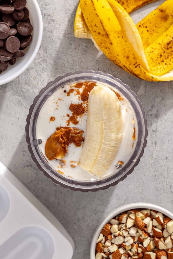 Bananas, Greek yogurt, peanut butter, milk, and cinnamon ready to be blended together for homemade ice cream bars