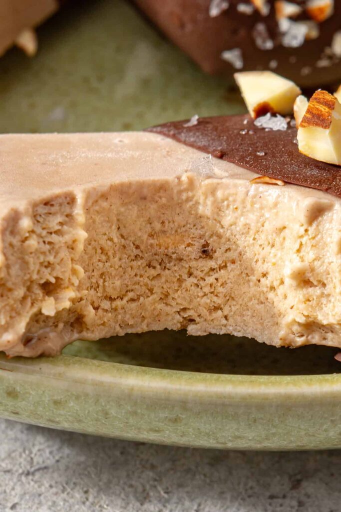 Close-up of a homemade banana ice cream bar with a bite showing its creamy frozen texture