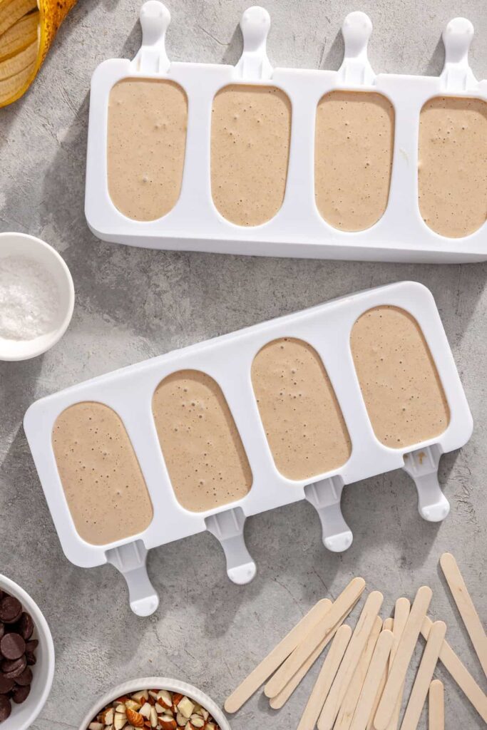 Homemade banana ice cream bars in molds ready to freeze until firm