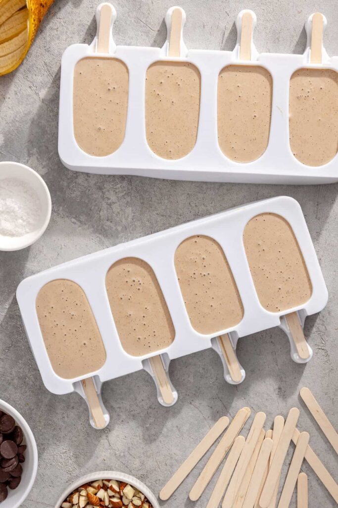 Banana Greek yogurt ice cream mixture poured into ice cream molds, ready to freeze