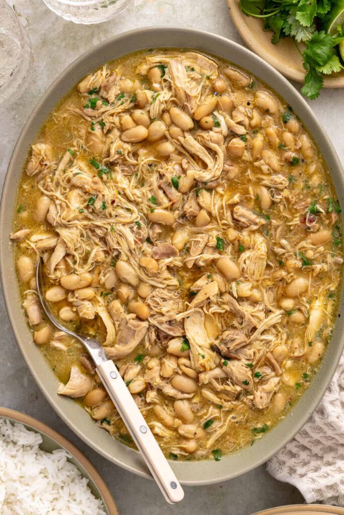 Green enchilada chicken and beans with fresh cilantro in a serving platter