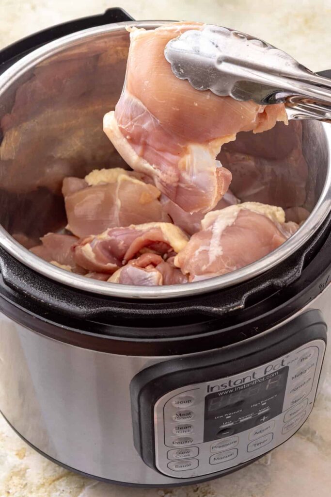 Chicken thighs in the Instant Pot ready to make green enchilada chicken