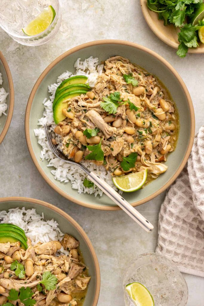 Overhead view of green enchilada chicken over rice with avocado and fresh cilantro