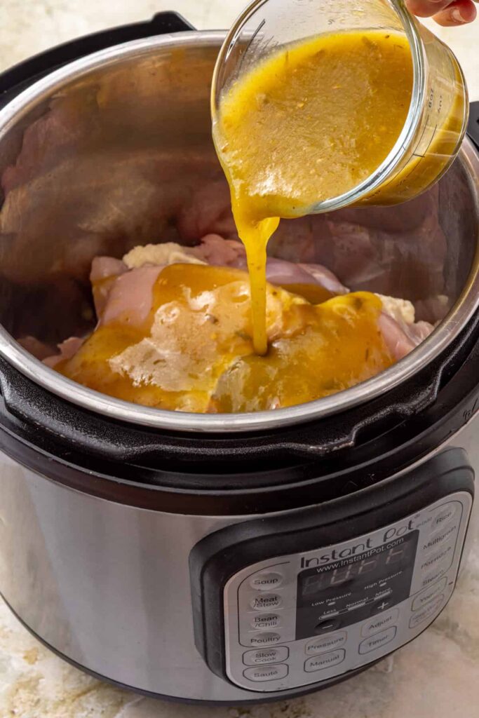 Adding green enchilada sauce to chicken thighs in the Instant Pot