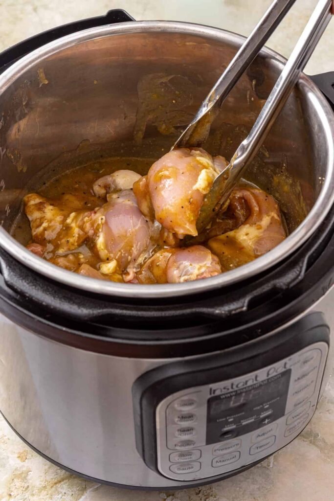 Chicken thighs tossed with green enchilada sauce and spices in the Instant Pot