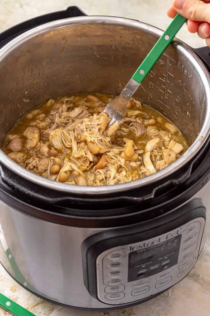 Green enchilada chicken and white beans warming together in the Instant Pot