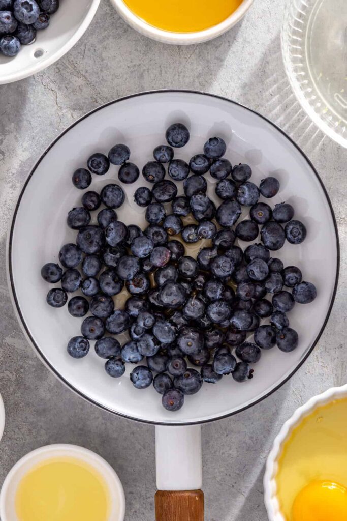 Fresh blueberries, honey and lemon juice in a saucepan for blueberry honey compote