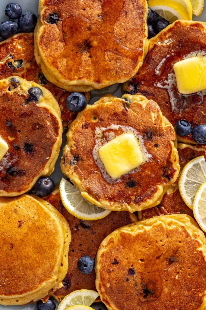 Close-up of lemon blueberry cottage cheese pancakes with melting butter and fresh blueberries