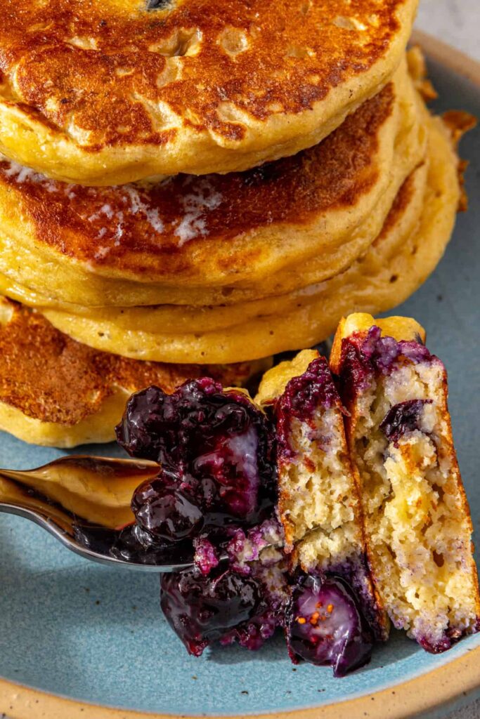 Close-up of fluffy lemon blueberry cottage cheese pancakes with blueberry compote and fresh blueberries