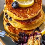 Fluffy lemon blueberry cottage cheese pancakes topped with blueberry compote, fresh blueberries and lemon slices