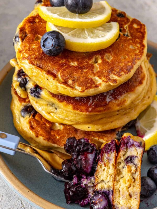 Fluffy lemon blueberry cottage cheese pancakes topped with blueberry compote, fresh blueberries and lemon slices