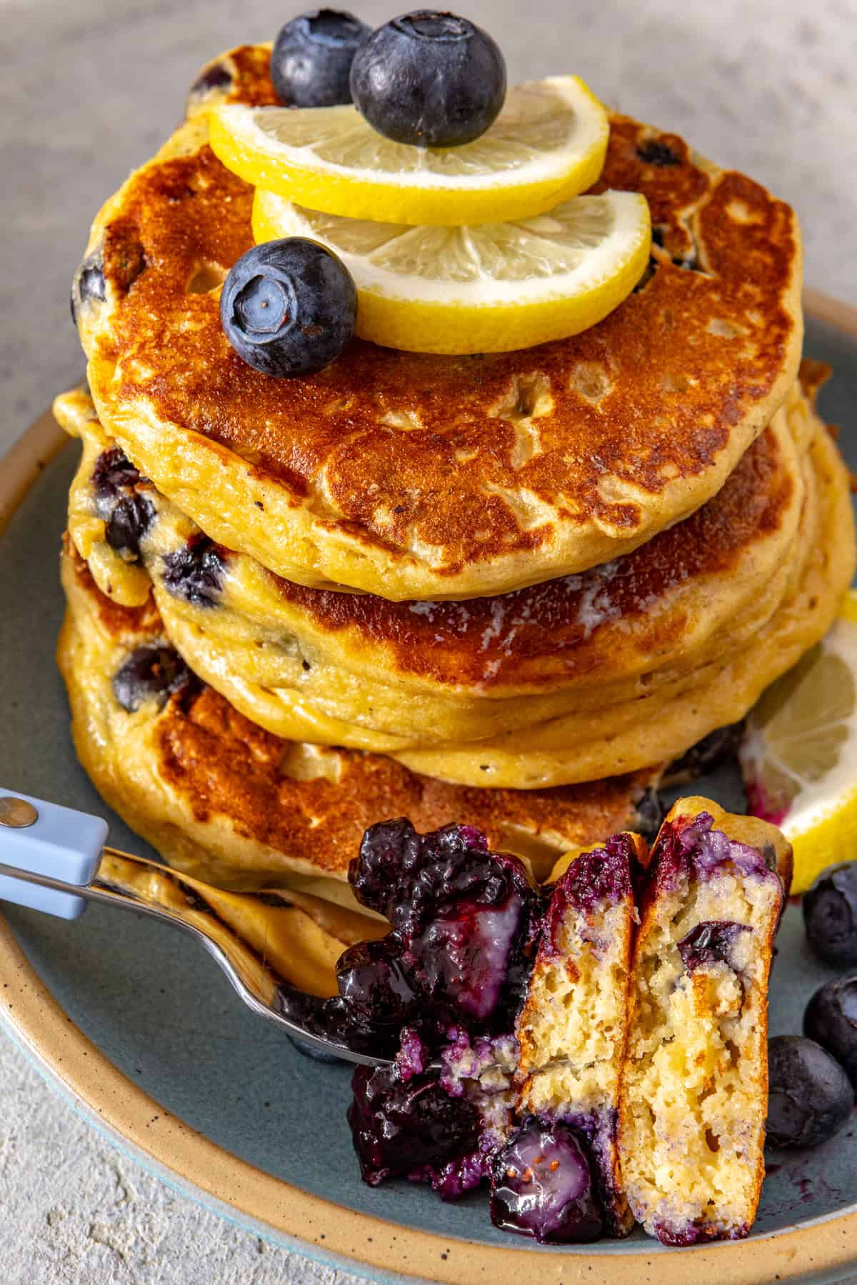Fluffy lemon blueberry cottage cheese pancakes topped with blueberry compote, fresh blueberries and lemon slices