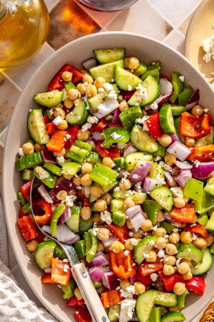 Chopped cucumber, bell pepper, chickpeas, red onion, capers, and feta in Mediterranean chickpea salad