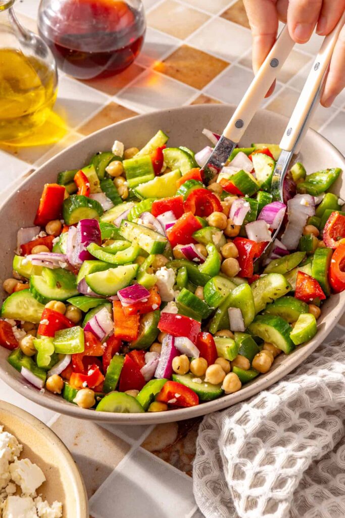 Serving Mediterranean chickpea salad with two serving spoons