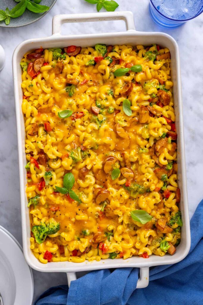 Fresh basil torn over baked broccoli cheddar pasta before serving