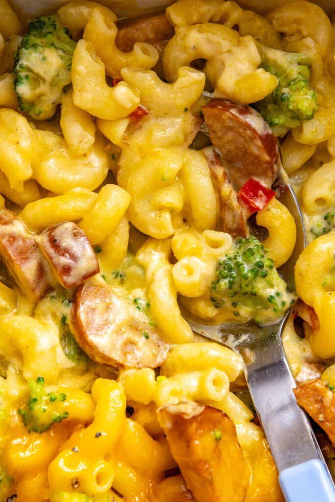 Close-up baked pasta showing chicken sausage, broccoli and melted cheddar